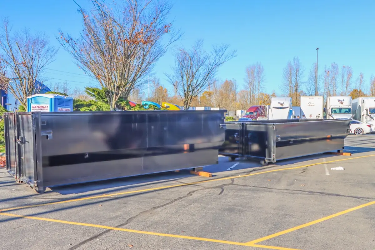 Professional dumpster rental service with roll-off container on residential driveway in Burton